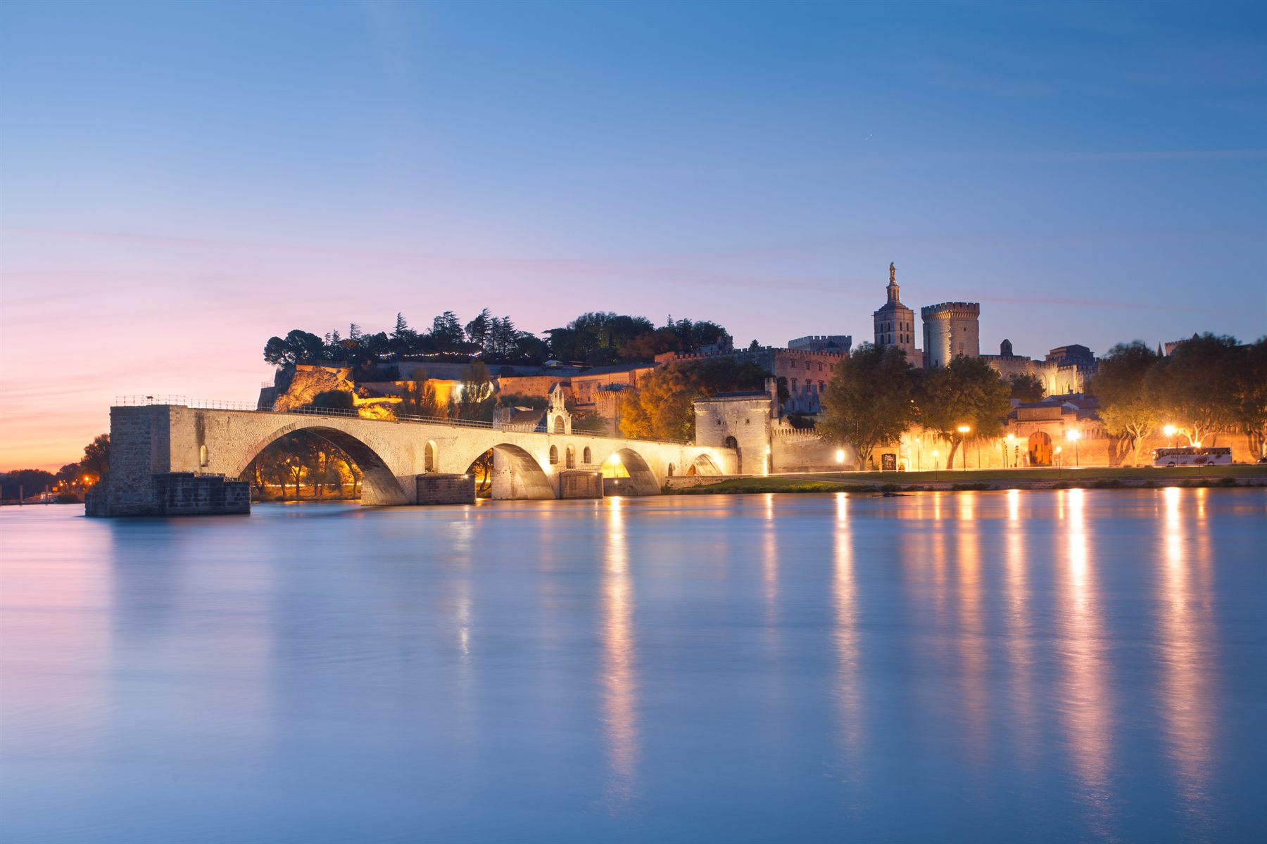 Avignon’s broken bridge and the Palais des Papes reflected in the Rhône at dawn